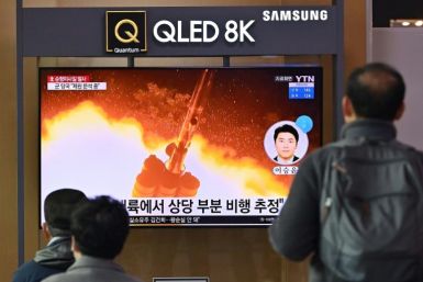 People watch a television in Seoul showing a news broadcast with file footage of a North Korean missile test