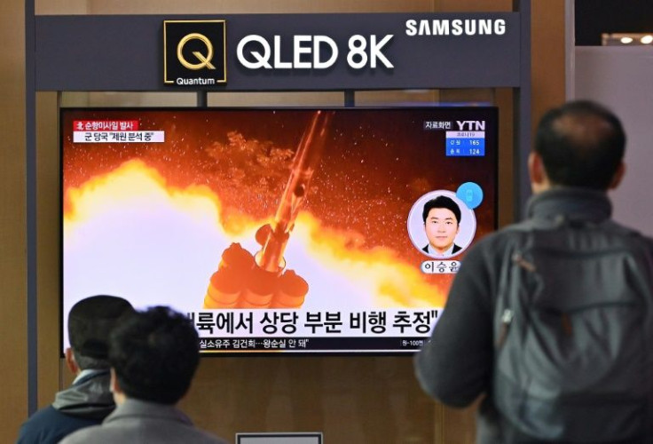 People watch a television in Seoul showing a news broadcast with file footage of a North Korean missile test