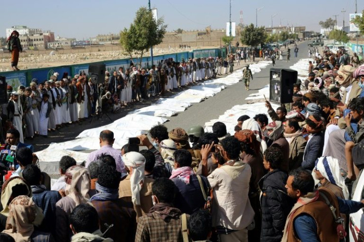 Onlookers gather as Yemenis pray during a mass funeral in rebel-held Saada for those killed in an attack on a prison, which the Huthis said claimed 91 lives and the Saudi-led coalition denied striking