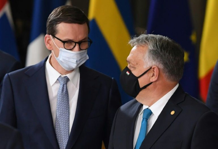 Poland's Prime Minister Mateusz Morawiecki (L) speaks with Hungary's Prime Minister Viktor Orban at the European Council building in Brussels in October 2021