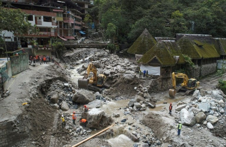 Workers clean up Machu Picchu Pueblo after the Alcamayo river broke its banks following heavy rains and flooded the town