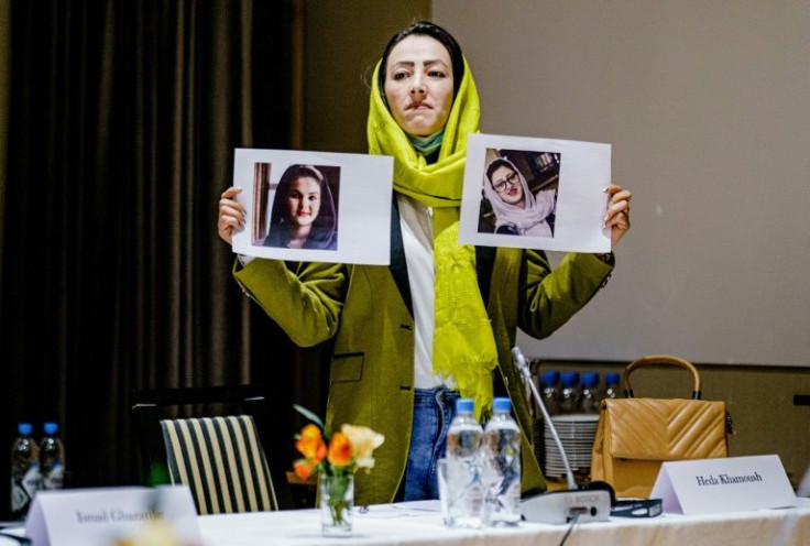 Delegate Heda Khamoush holds up photos of womenâs rights activists recently detained in Afghanistan as she attends a meeting with international special representatives and representatives of Afghans with a background from civil society on January 24, 20