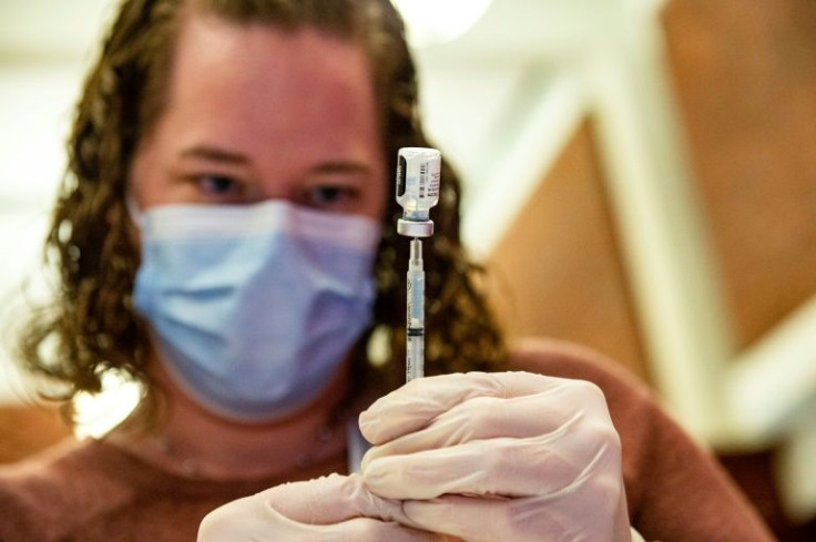 A health care worker prepares to inject a patient with a Covid-19 vaccine