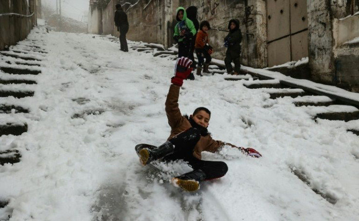 Palestinian children play in the snow in the flashpoint West Bank city of Hebron