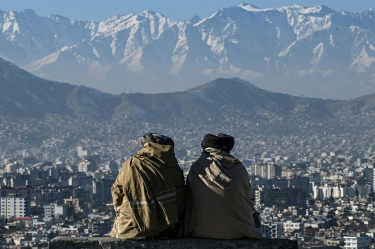 Taliban members sit overlooking Kabul on January 20, 2022