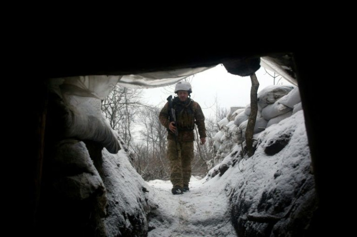 An Ukrainian Military Forces serviceman walks along a snow covered trench on the frontline with the Russia-backed separatists near Zolote village, in the eastern Lugansk region, on January 21, 2022