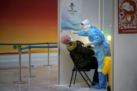 A news cameraman undergoes a Covid-19 test upon arrival at Beijing airport