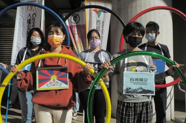 Activists in Taipei, Taiwan hold up banners and the five Olympic Rings to protest against the 2022 Games