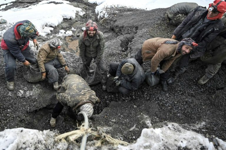 Afghan workers perform clean raw stones with water before searching for emeralds in the bitter cold of the Mikeni Valley in Panjshir province