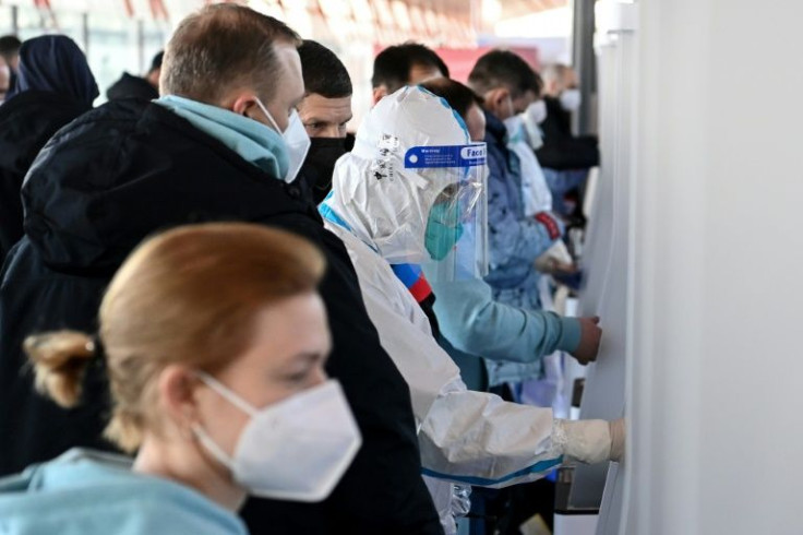 Russian Olympic team members scan their QR health code after arriving at Beijing Capital International Airport