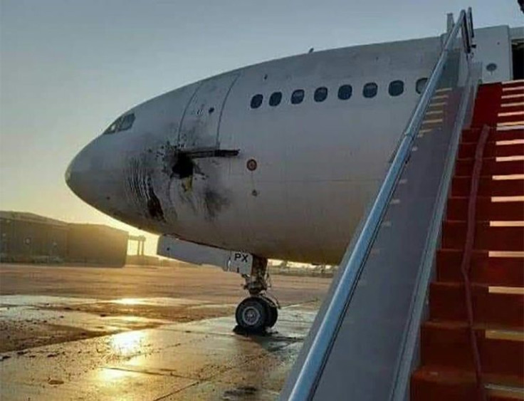 A handout picture released by the Facebook page of the Iraqi ministry of transportation, shows a damaged stationary aircraft on the tarmac of Baghdad airport, after rockets reportedly targeted the runway, on January 28, 2022