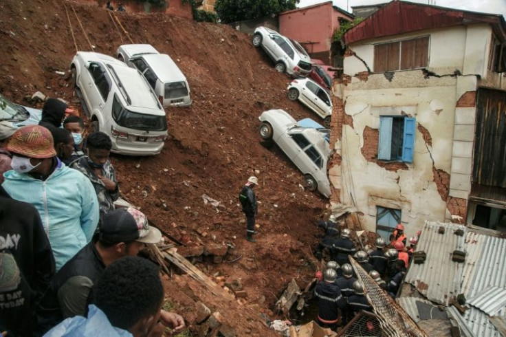Firefighters search rubble after a car park collapsed on houses following the heavy rains in Antananarivo
