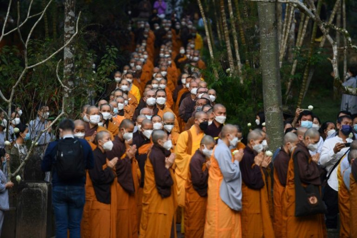 Thich Nhat Hanh's remains were brought to an open cremation site on Saturday morning, followed by a crowd of tens of thousands including Buddhist monks in yellow and brown robes and followers dressed in grey