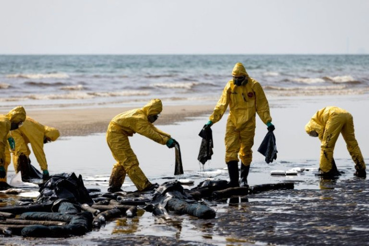 Crews in yellow plastic protective suits were seen at Mae Ram Phueng Beach