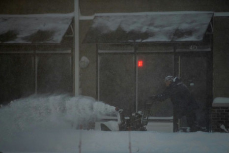 A man uses a snow blower to clear snow at a strip mall in Stony Brook, New York during a blizzard that hit the Northeastern United States on January 29, 2022