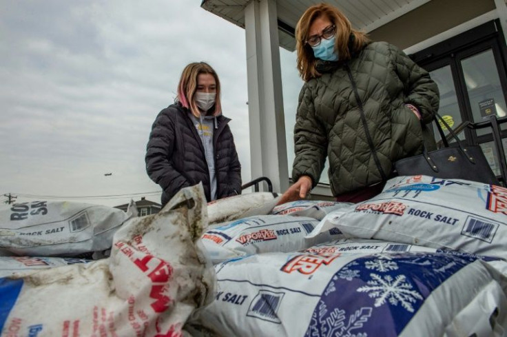 Customers inspect the different kinds of snow and ice melt available a hardware store in Winthrop, Massachusetts in preparation for the oncoming storm on January 28, 2022