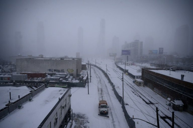 A snow plow makes its way along a street in the Brooklyn borough of New York on January 29, 2022