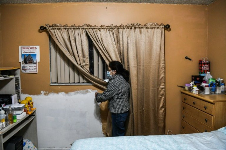 Maria Ruby looks at wall repairs in her house in Hialeah, Florida, where her rent is going to shoot up 65 percent -- more than she can afford