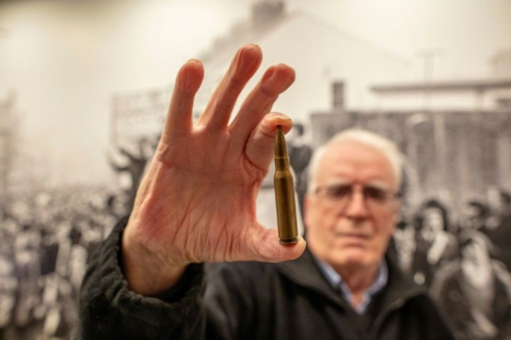 At the Free Derry Museum, John Kelly holds a 7.62 mm calibre bullet like the one that killed his brother