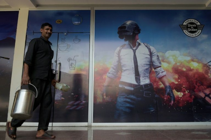 A man walks past a poster for the PlayerUnknown's Battlegrounds game at an internet cafe in Rawalpindi