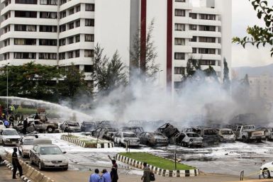 Members of the emergency services work at the scene of an explosion at a police station after a suspected suicide bomber was killed and many vehicles were destroyed inAbuja