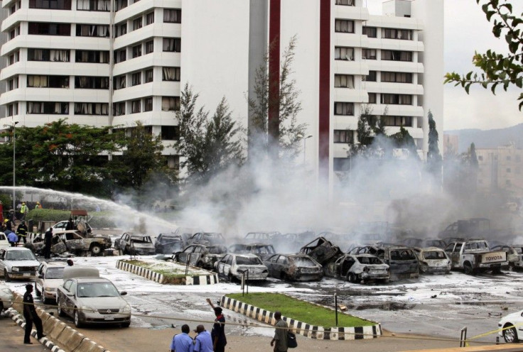 Members of the emergency services work at the scene of an explosion at a police station after a suspected suicide bomber was killed and many vehicles were destroyed inAbuja