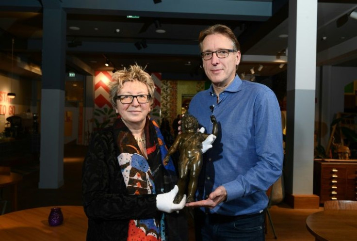 Dutch art detective Arthur Brand hands over the long-lost bronze sculpture to to Catherine Monnet, director of the Musee du Pays Chatillonnais in eastern France