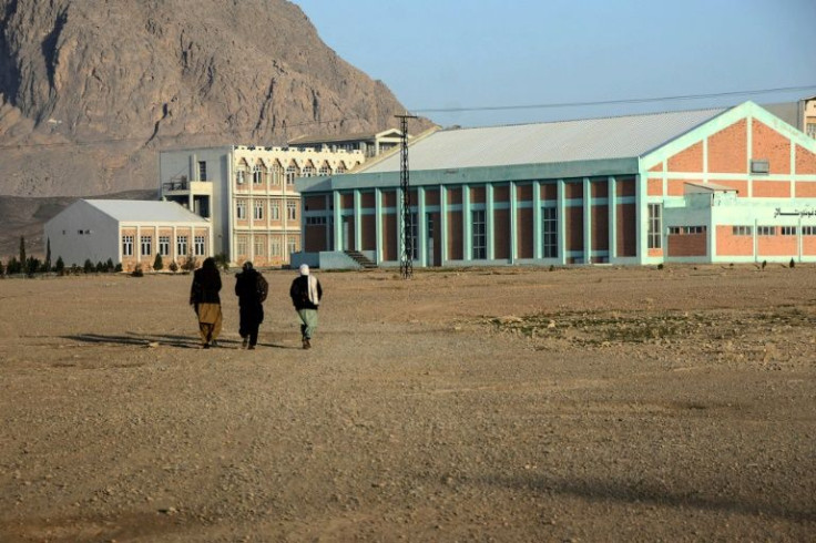 Students walk towards a Kandahar University building after the facility reopened
