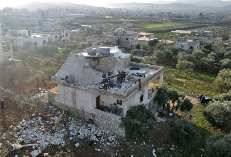 A Syrian civil defence team surveys the damage to a two-storey house on the outskirts of the rebel-held town of Atme that appears to have been one of the main targets of the US raid