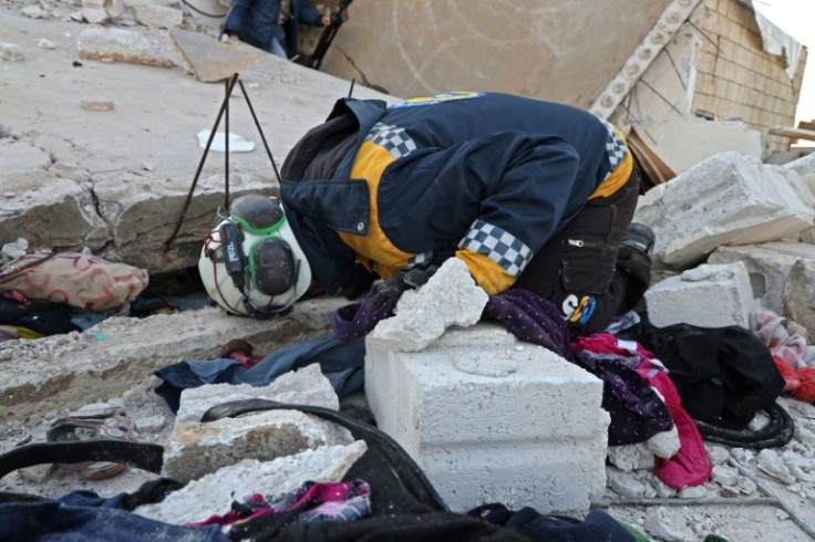 A Syrian civil defence volunteer combs the rubble of the building which bore the scars of an intense battle