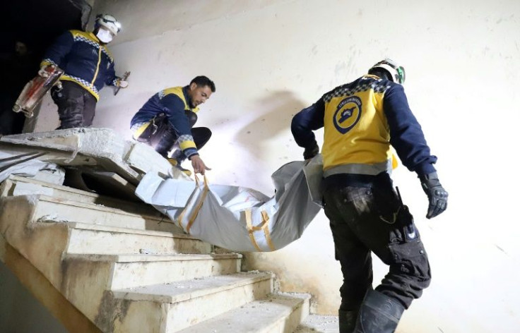 A Syrian civil defence team carries away a body after the pre-dawn US raid
