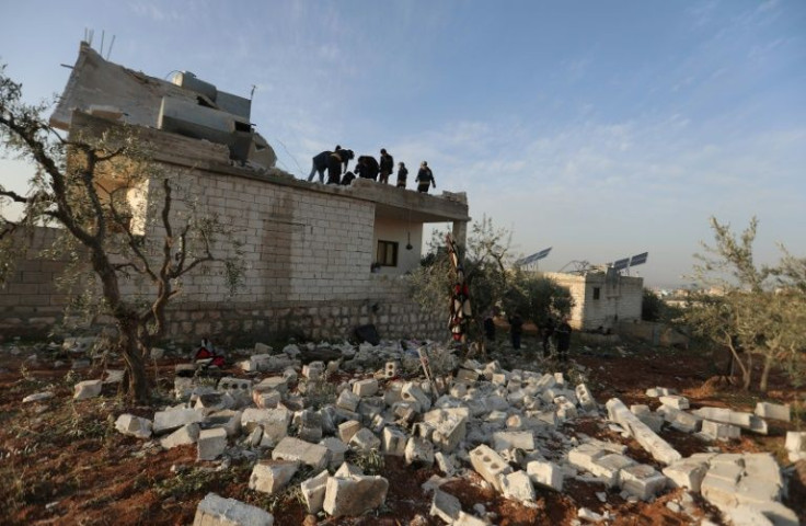 Syrians gather at the scene following an overnight raid by US special operations forces in Syria