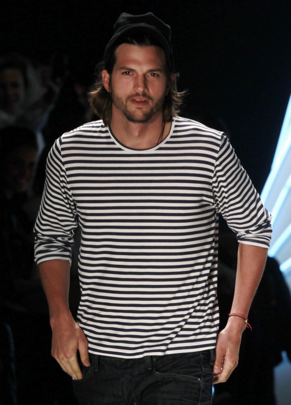 U.S. actor Ashton Kutcher presents a creation from Colccis Summer 2012 collection during Sao Paulo Fashion week