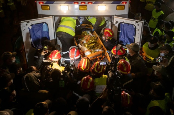 Moroccan emergency services teams carry the body of five-year-old Rayan into an ambulance after pulling him from a well shaft