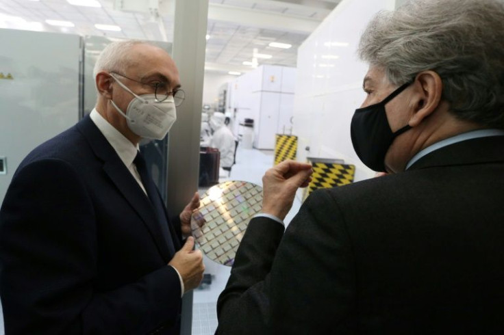 IMEC chief executive officer Luc Van den Hove (L) holds a wafer as he speaks with European Commissioner for Internal Market Thierry Breton at his firm's leading semiconductor research hub in Belgium