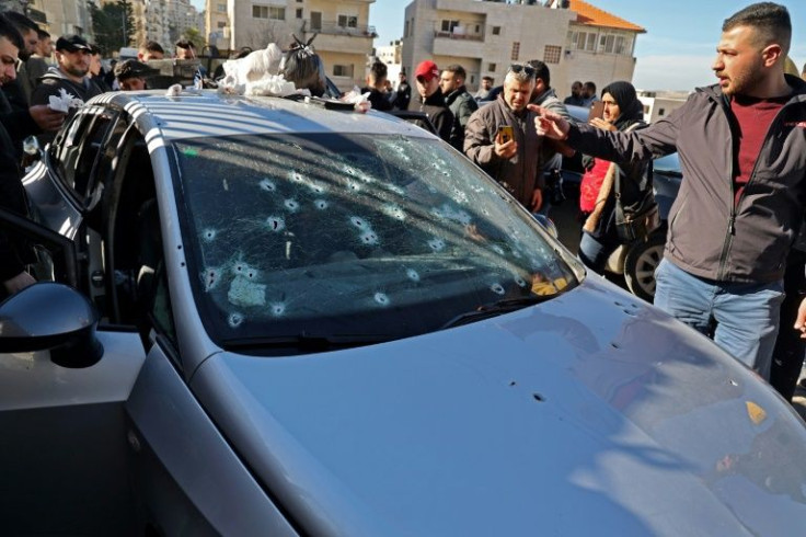 Palestinians inspect the bullet-riddled car in which three Palestinians were travelling when they were shot dead by Israeli troops in a raid in the West Bank city of Nablus