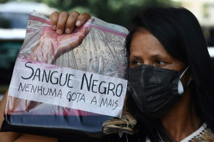 A woman holds a bag with mock blood that reads "Black Blood, not one more drop" during an anti-racism protest after Moise Kabagambe's killing