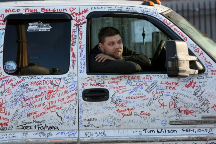 A driver looks out from his truck covered in support messages, as demonstrators continue to protest the vaccine mandates and other public health measures