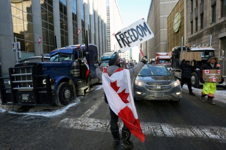 A person holds a sign reading "Freedom" as truckers and supporters continue to protest against mandates and restrictions related to Covid-19 vaccines in Ottawa