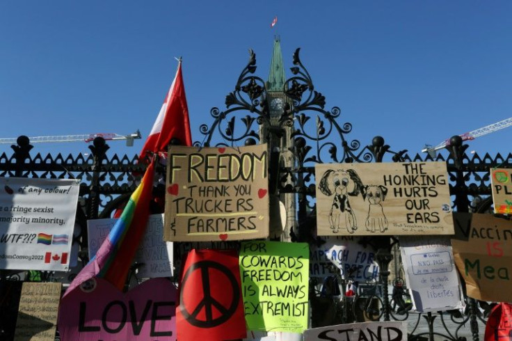 The front gate of the Canadian parliament is covered with banners protesting vaccine mandates