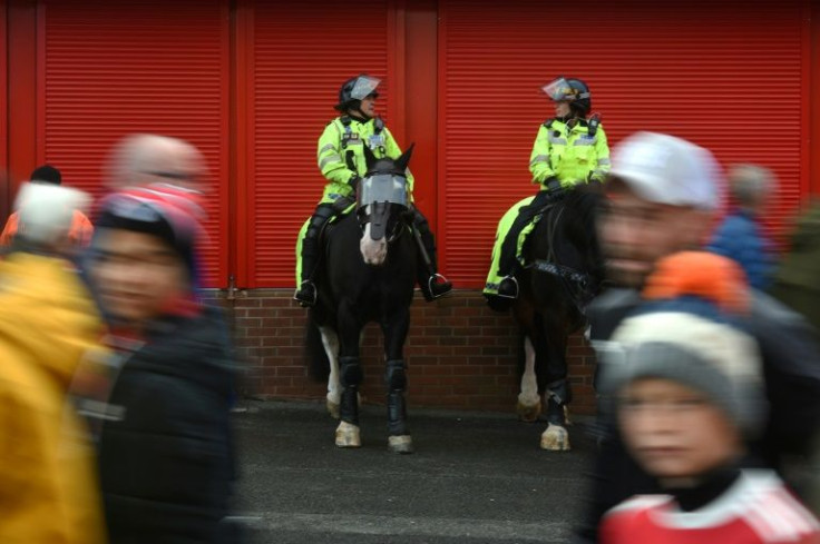Mounted police monitor fans before a match at Old Trafford