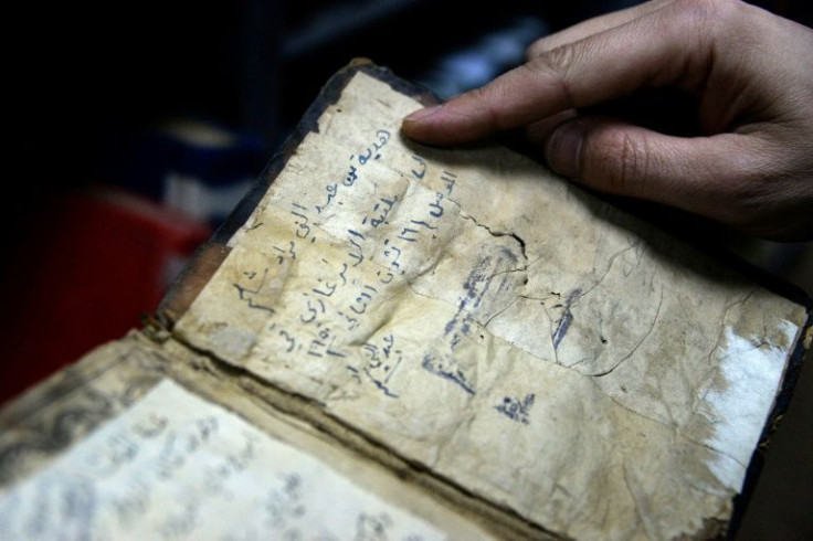 A librarian shows a book from University of Iraq's northern city of Mosul, one of those that escaped destruction at the hands of the Islamic State group