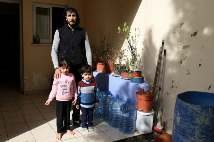 Syrian refugee Nayef al-Shouyoukh, 32, stands with his children at the Saint Nicolas residential complex. 'I don't know where to go. I am barely surviving,' he says