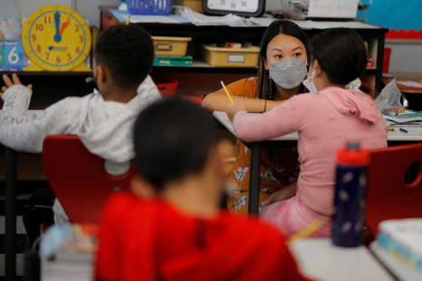 Teacher Mary Yi works with a fourth grade student at the Sokolowski School, where students and teachers are required to wear masks because of the coronavirus disease (COVID-19) pandemic, in Chelsea, Massachusetts, U.S., September 15, 2021.   