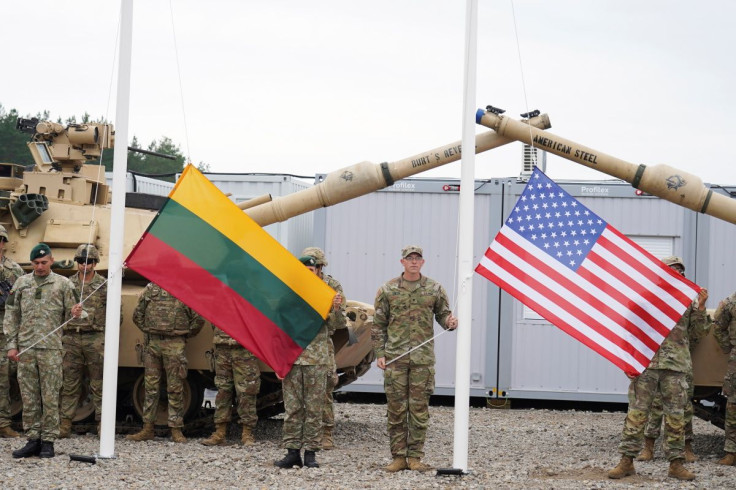 Soldiers hold Lithuanian and U.S. flags during the opening ceremony of the U.S. army camp Herkus, in Pabrade, Lithuania, August 30, 2021. 