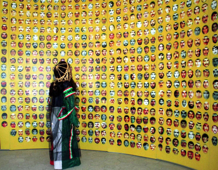 A young girl in Kuwaiti national dress looks up at pictures of hundreds of people missing since the 1990-1991 Gulf Crisis, on display at a major celebration marking the end of Iraq's occupation of Kuwait 10 years ago, in Kuwait City, February 25, 2001. 