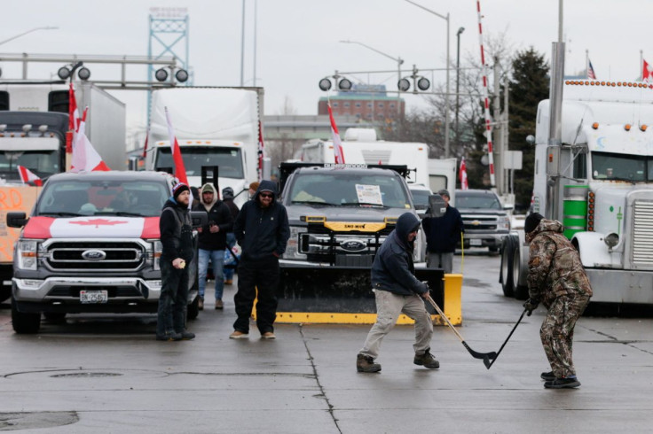 People play hockey while vehicles block the route leading from the Ambassador Bridge, linking Detroit and Windsor, as truckers and their supporters continue to protest against the coronavirus disease (COVID-19) vaccine mandates, in Windsor, Ontario, Canad