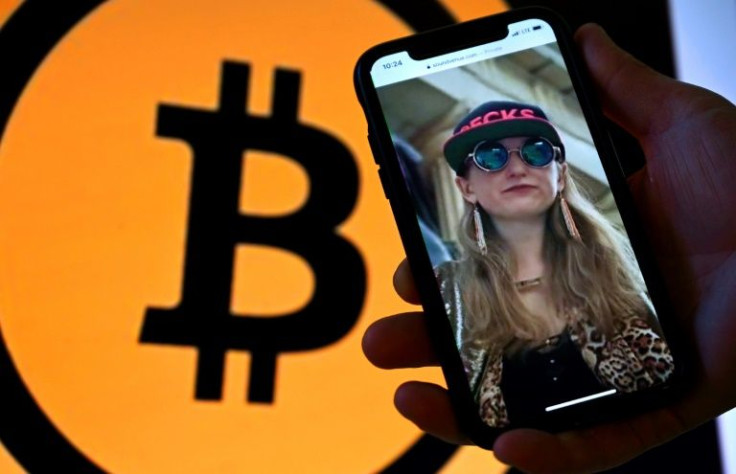A picture of Heather Morgan, also known as "Razzlekhan," on a phone in front of the Bitcoin logo
