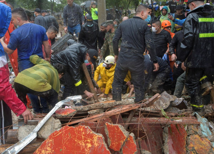 Police, firefighters and rescue workers recover the body of a woman who died following a landslide caused by heavy rains, that killed and injured residents and destroyed homes, in Pereira, Colombia, February 8, 2022.