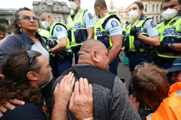 Protesters resist police before they moved in to evict mandate protesters in parliament grounds in Wellington on February 10, 2022